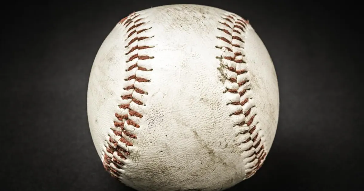 Close-up of a worn baseball with red stitching
