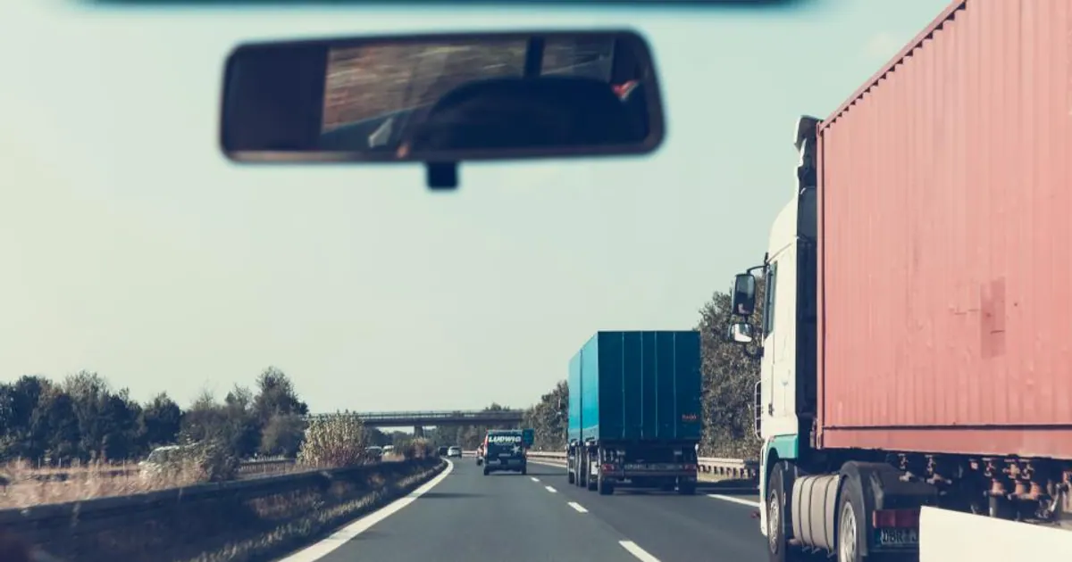 Truck on a highway seen through a vehicle windscreen