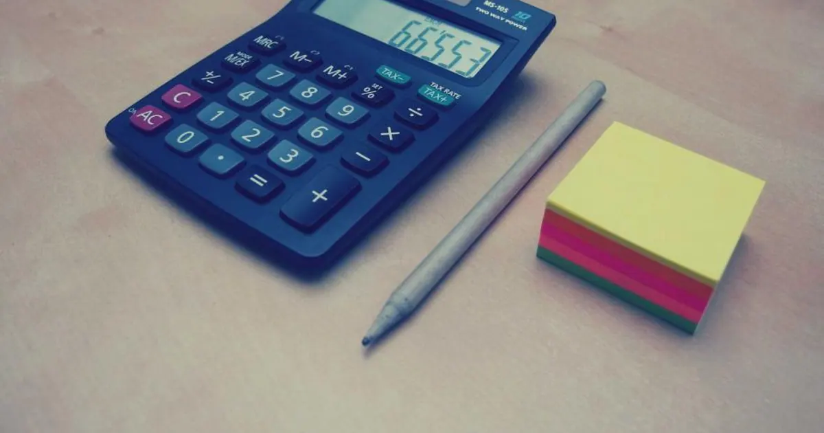 Blue calculator, pen and sticky notes on a desk