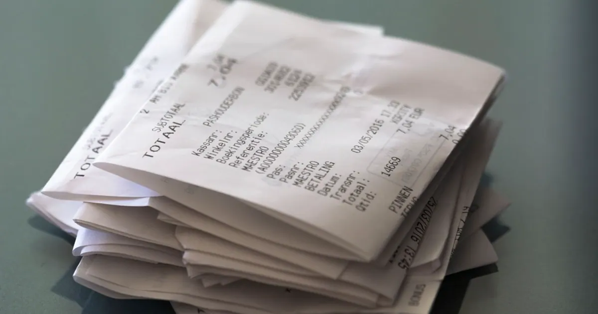 A stack of crumpled paper shopping receipts