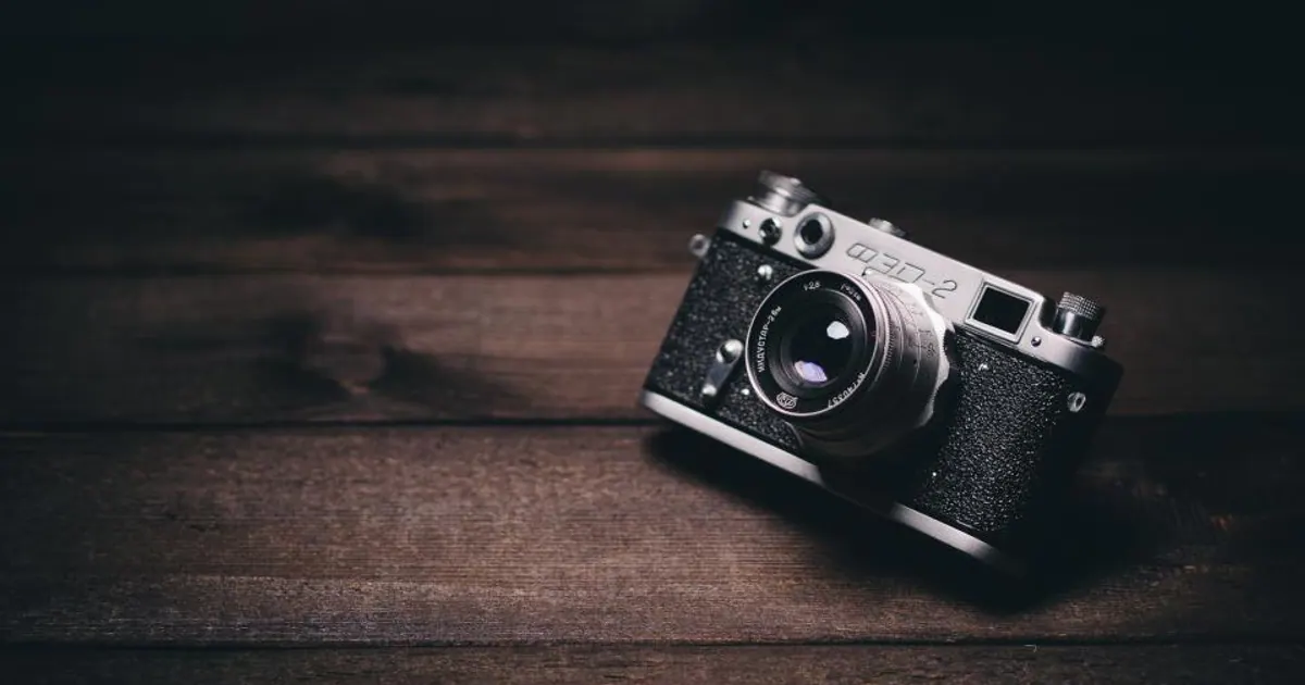Compact camera lying on a dark wooden table