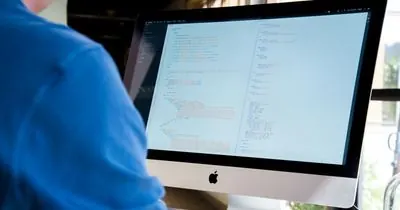 Developer working on code at a large monitor