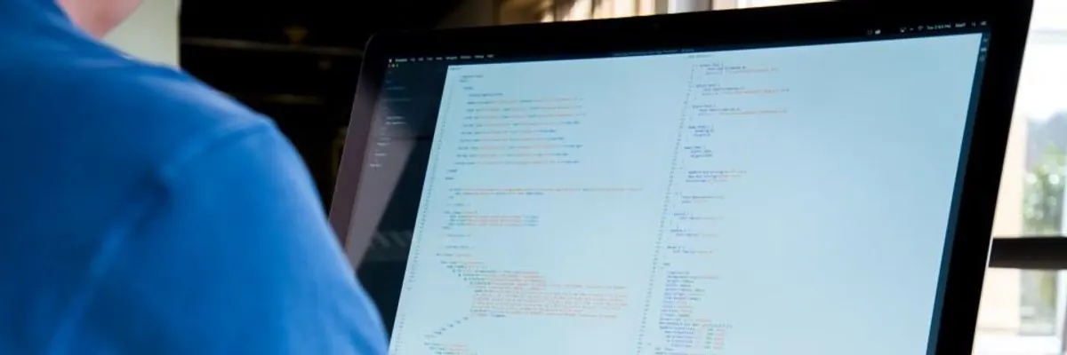 Developer working on code at a large monitor