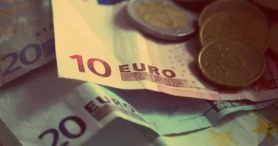 Euro coins and banknotes spread on a table