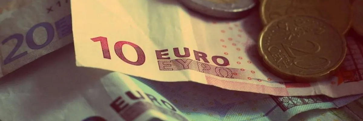 Euro coins and banknotes spread on a table